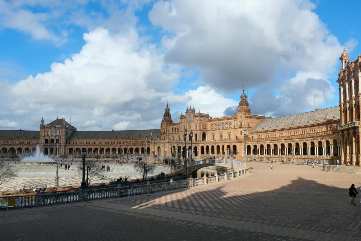 Sunny view of Plaza de España, Seville's iconic architectural landmark.