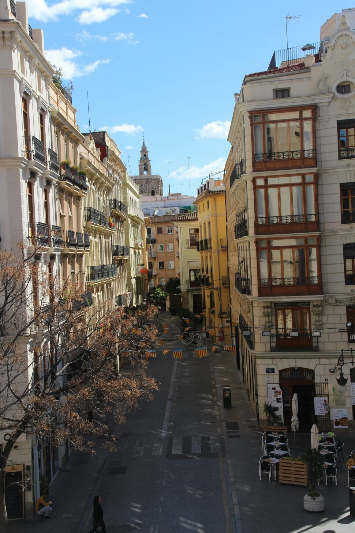 Charming view of a street lined with historic buildings in the heart of Valencia, Spain.